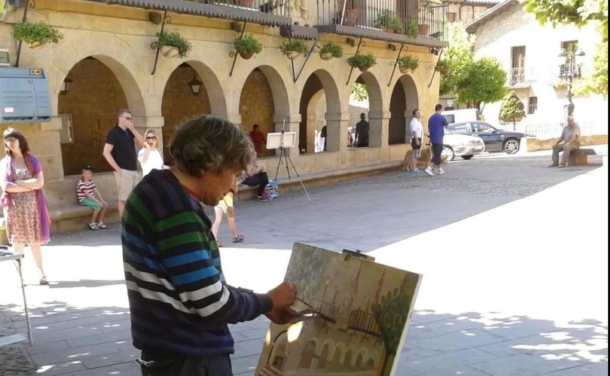 Un artista, en una anterior cita, pinta la fachada del Ayuntamiento. 