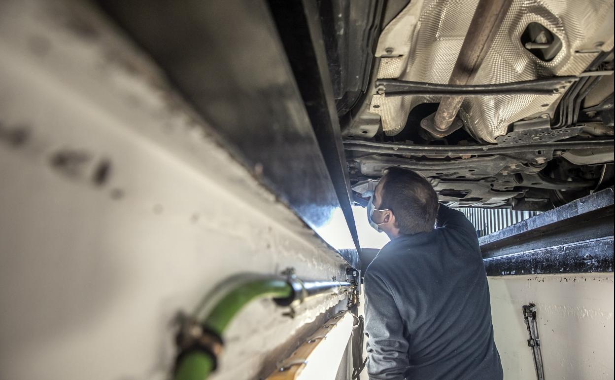 Un mecánico realiza la inspección de un coche. 