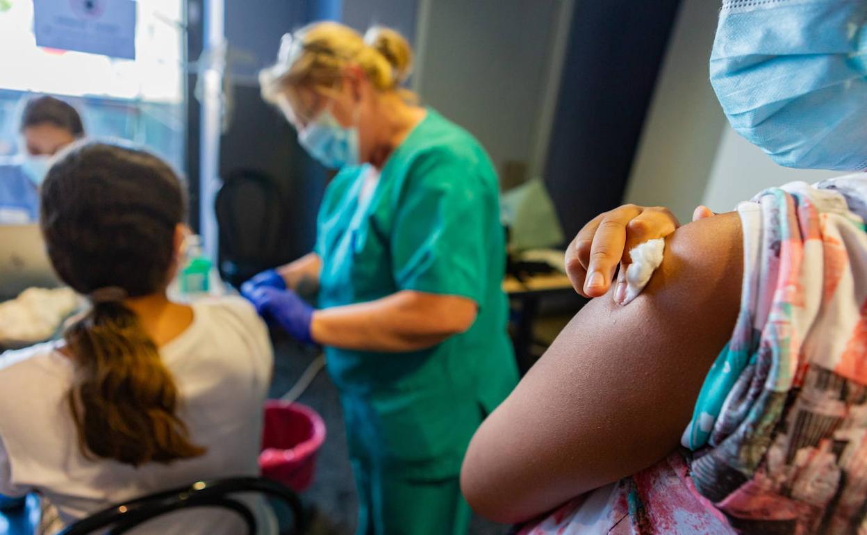 Dos mujeres vacunándose contra el COVID 