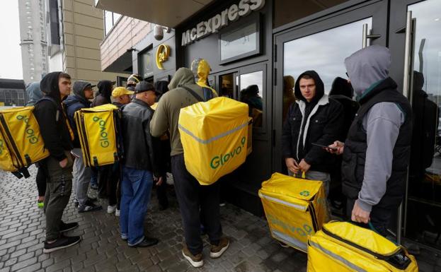 Trabajadores de Glovo, recogiendo comida en un McDonald's. 