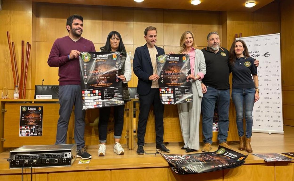 Los organizadores posan con el cartel del evento.