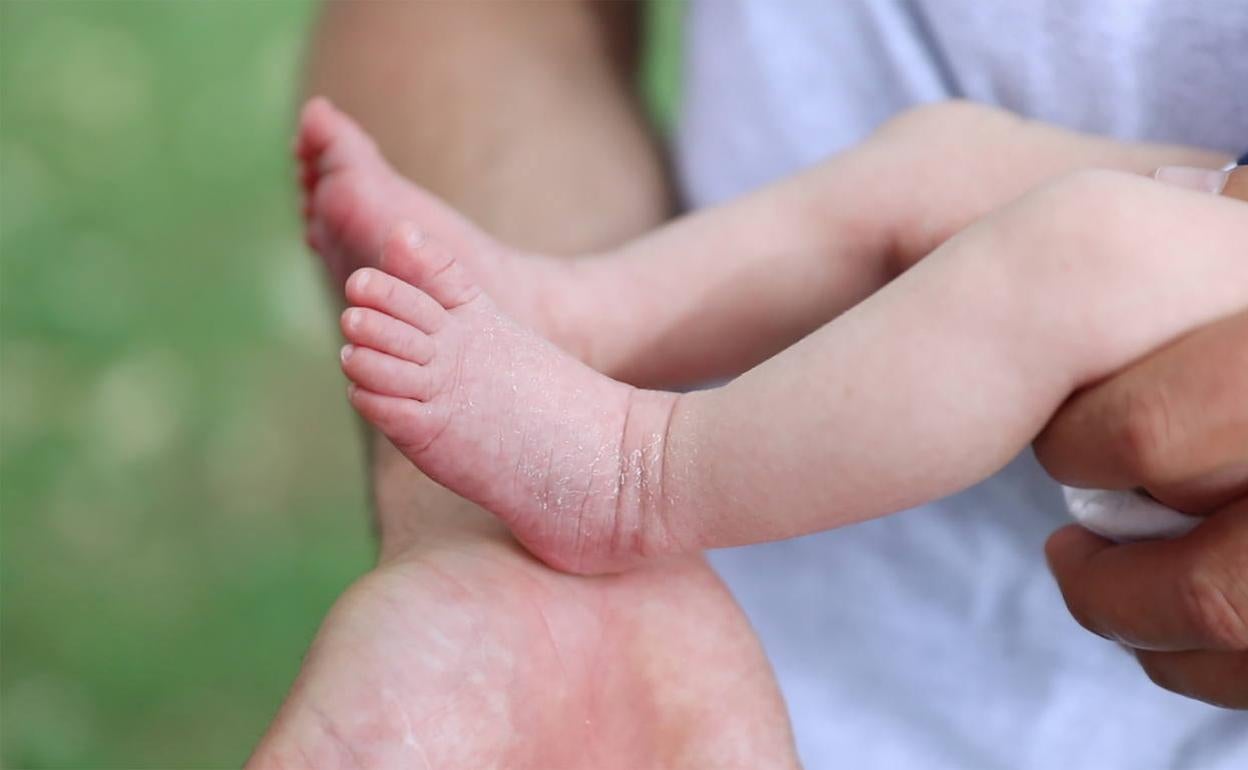 Un bebé, en brazos de su padre