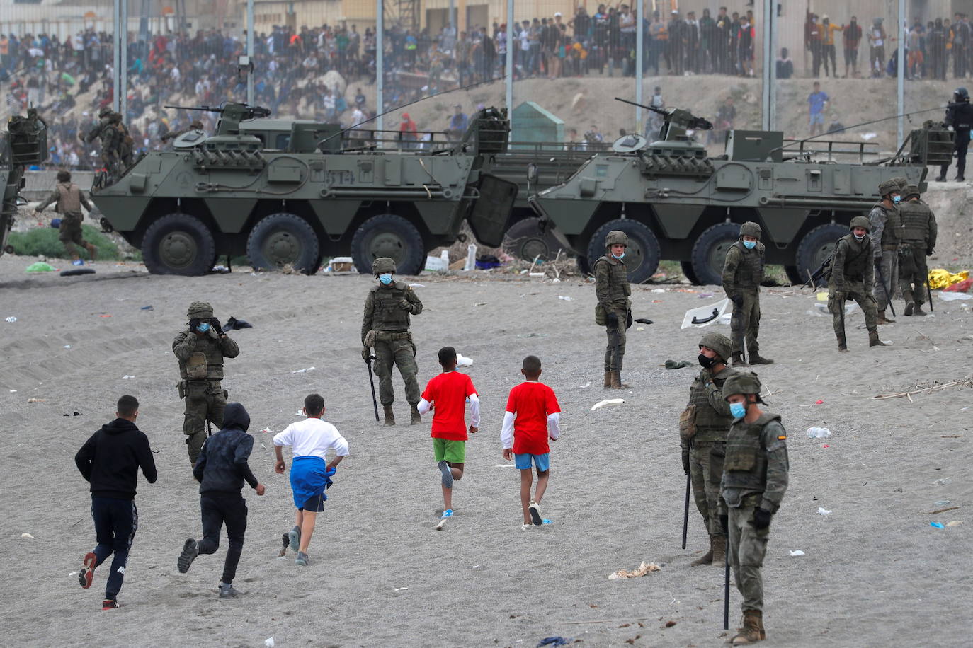 Imagen de menores marroquíes corriendo por una playa de Ceuta durante la crisis migratoria de 2021. 