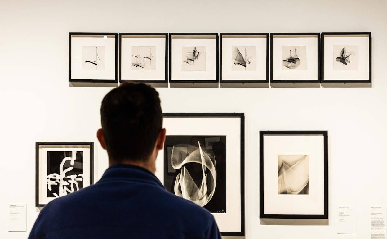 Un visitante observa algunas de las fotografías de la muestra 'Visiones expandidas'. 