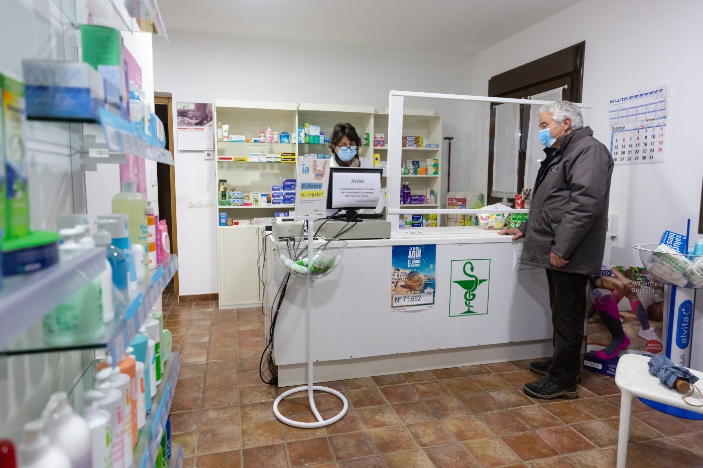 Tras el mostrador. Carmen atiende a un paciente en la farmacia de Zarratón. 