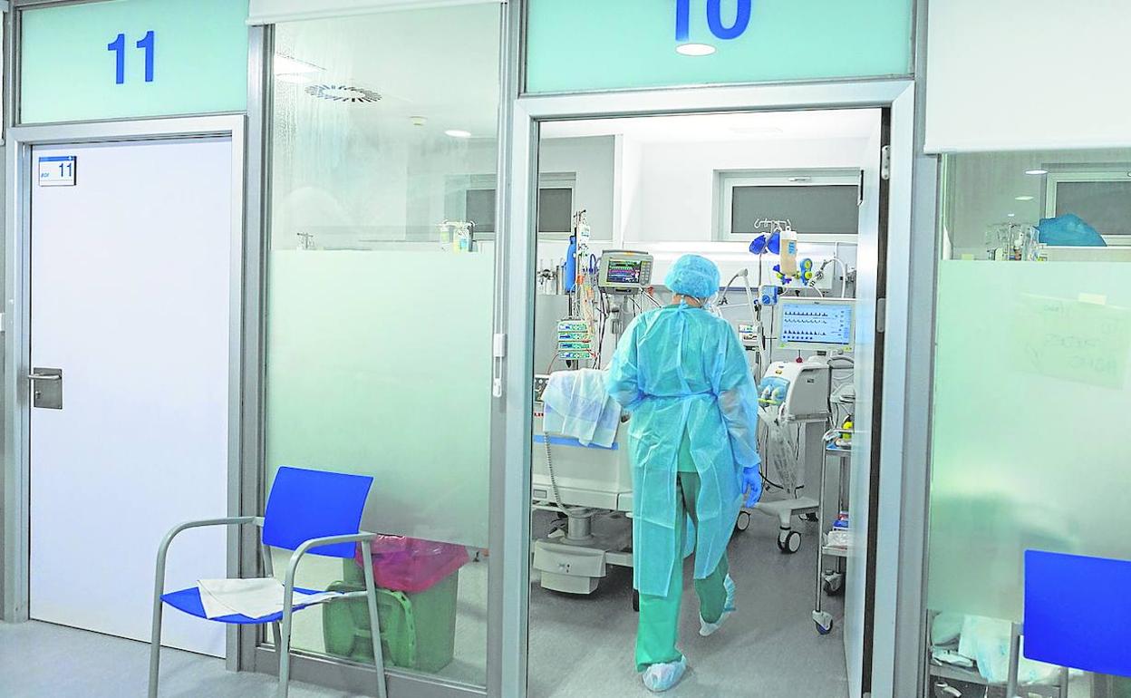 Una sanitaria accede a uno de los bóxer de la UCI para atender a uno de los pacientes ingresados por COVID, el pasado año. 