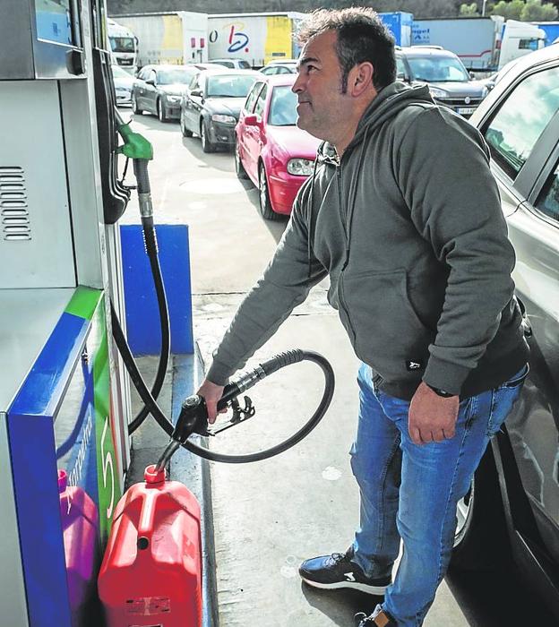 Un hombre hace acopio de combustible en una garrafa.