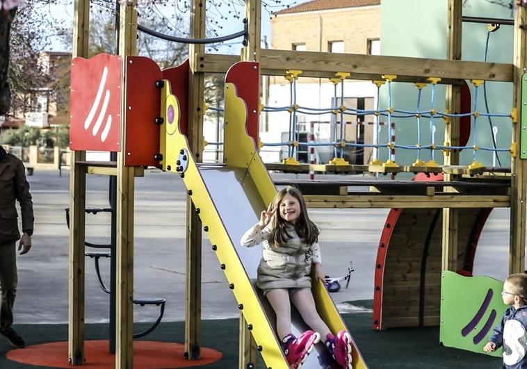 Una niña juega en el parque infantil de Ventas Blancas junto a sus hermanos y padres.