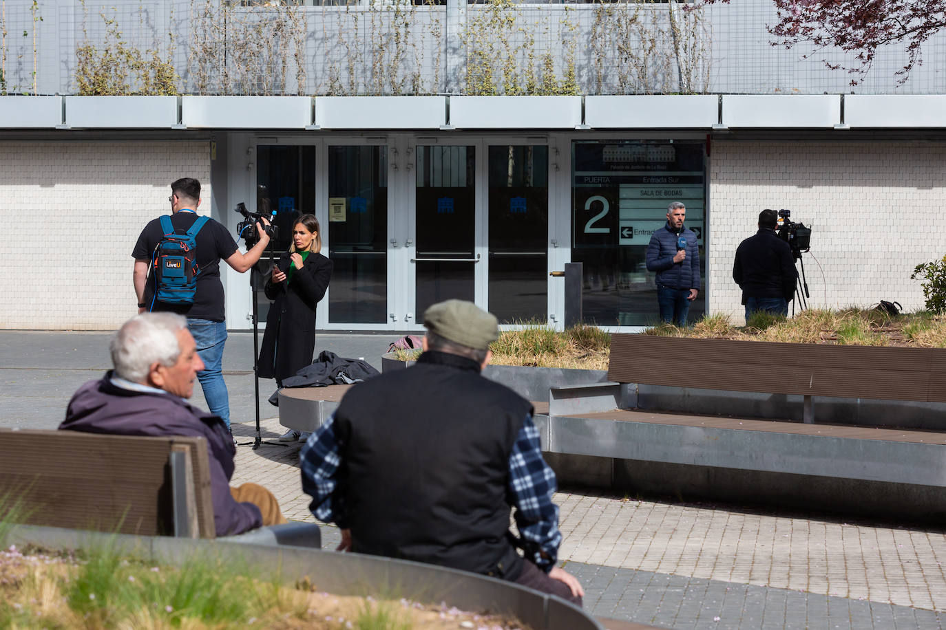 Algunos ciudadanos presencian cómo los medios cubren el juicio en el exterior del Palacio de Justicia. 