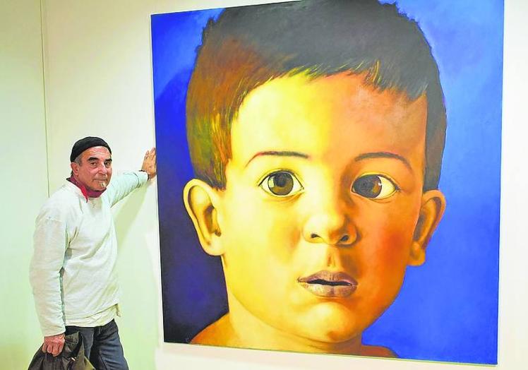 Luis Burgos, junto al retrato de su hijo.