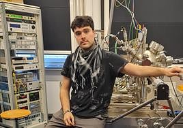 Arturo, con el microscopio que utiliza y sus siglas con átomos.