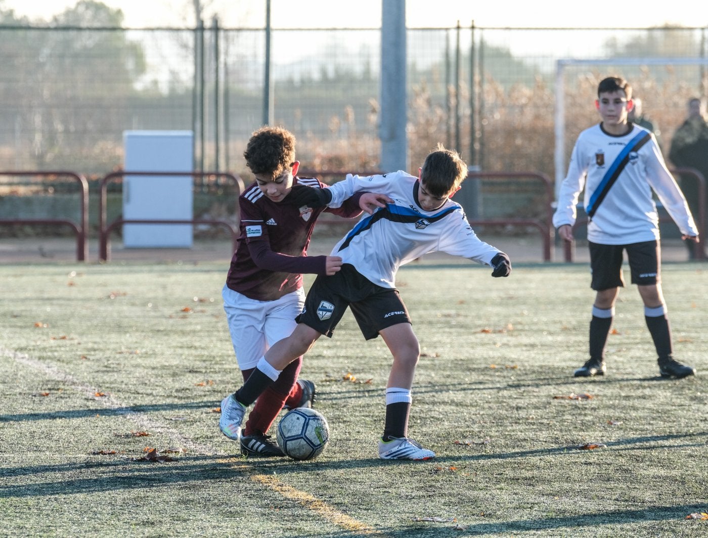 Un jugador del Valvanera protege el balón, acosado por un rival.