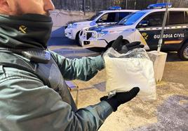 Un agente sujeta el paquete con la droga incautada.