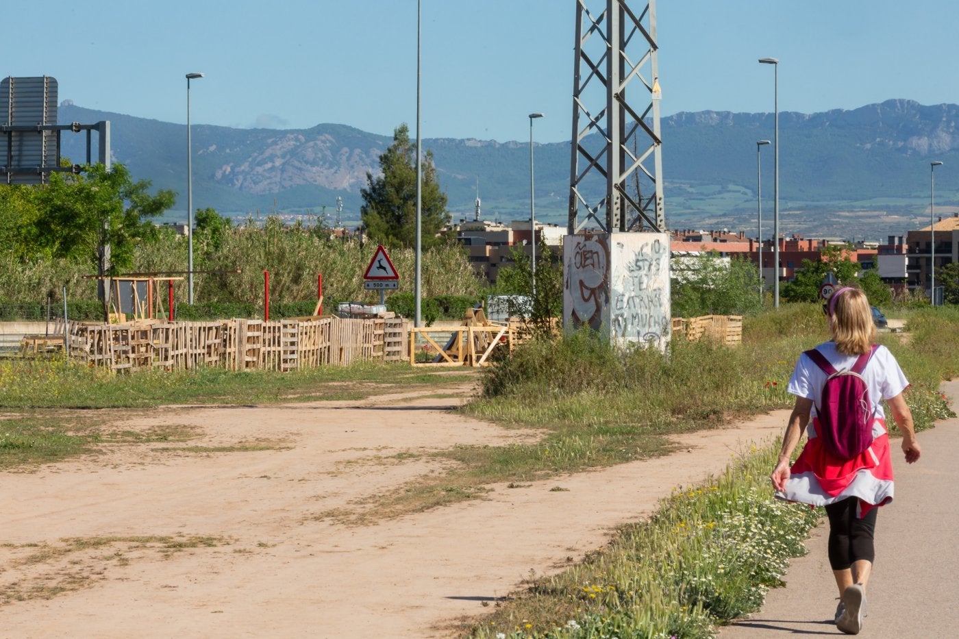 Una viandante observa la creciente ocupación de terrenos en los límites entre Logroño y Lardero.