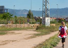 Una viandante observa la creciente ocupación de terrenos en los límites entre Logroño y Lardero.