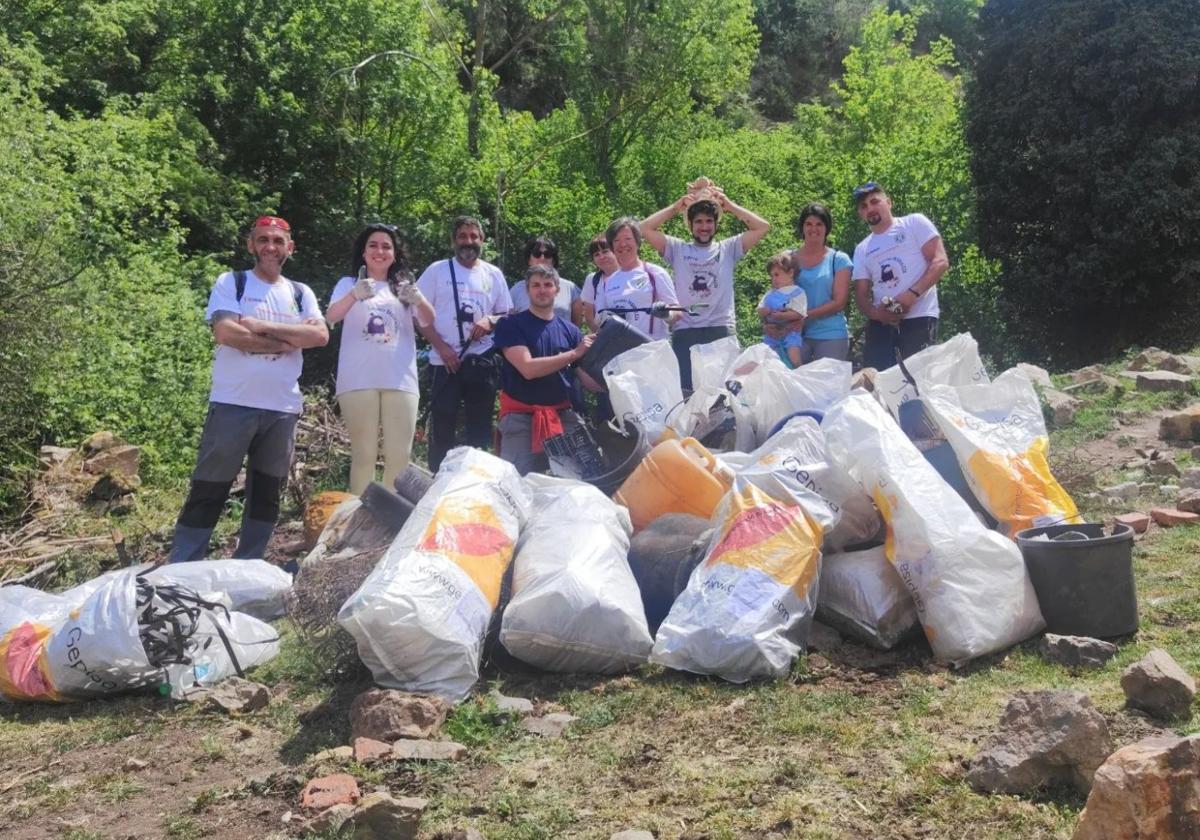 Miembros del Comando Basuraleza y vecinos de Ajamil de Cameros posan con parte de la basura recogida el pasado domingo.