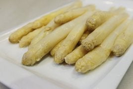 Un plato de espárragos, recién cocidos y aliñados con aceite.
