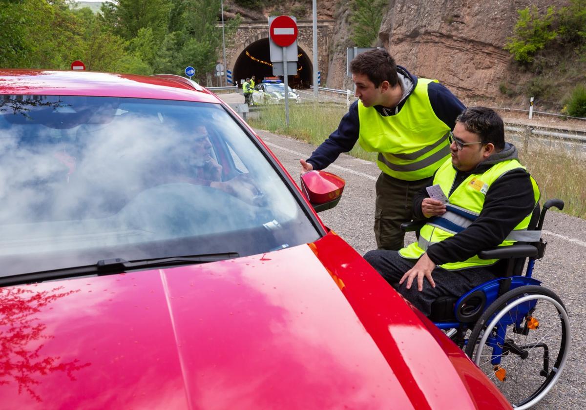 Dos usuarios del CRMF de Lardero, víctimas de accidente, conversan con un conductor, con el coche de Tráfico junto al túnel de Viguera.