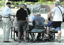 Un grupo de jubilados se entretiene con un juego de mesa al aire libre.