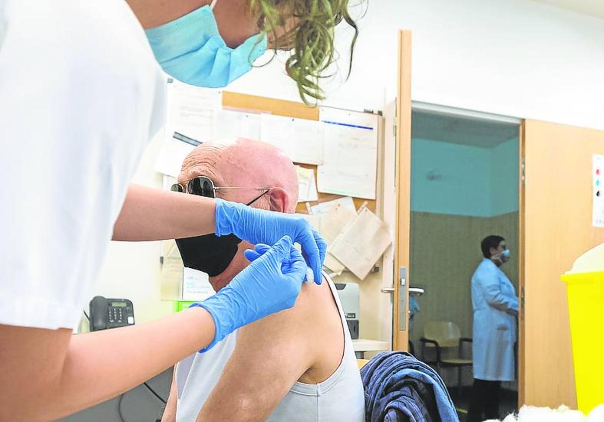 Una enfermera administra la vacuna frente a la gripe a un paciente.