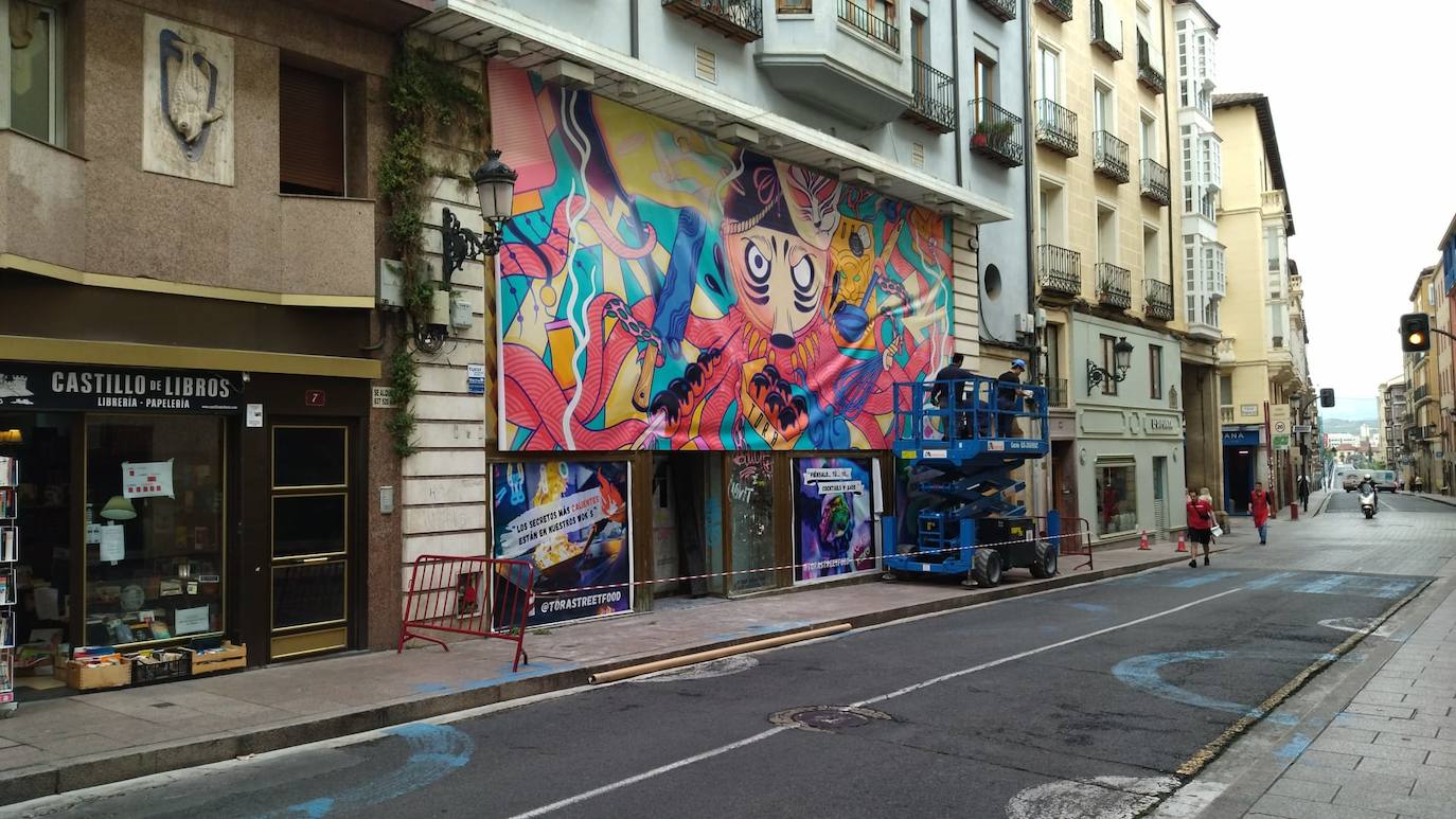 Operarios colocan una lona en el local que ocupó durante décadas 'La Granja'.