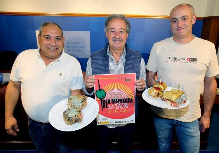 Ricardo García (izquierda), Francisco Martínez (centro) y Jaime Álvarez (derecha) junto al cartel del Día Mundial de la Tapa en la FER