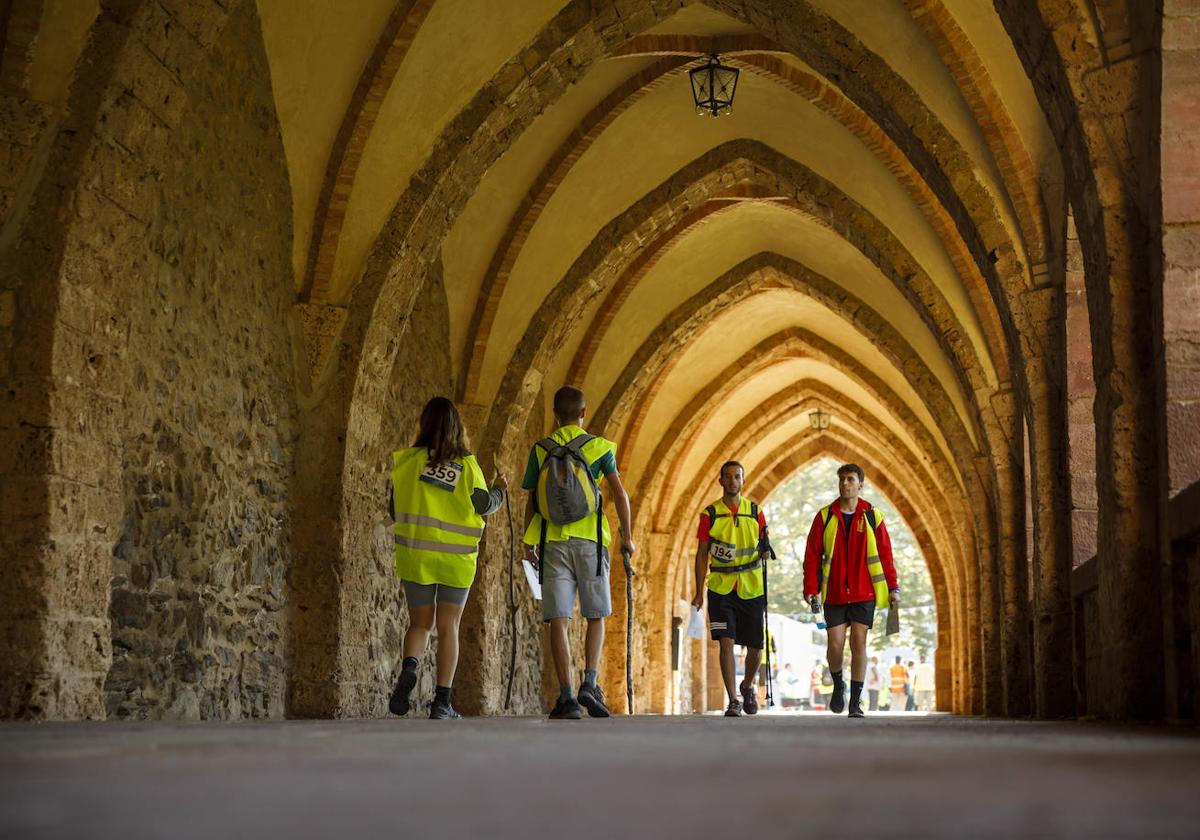 Los romeros cruzan bajo los arcos del monasterio.