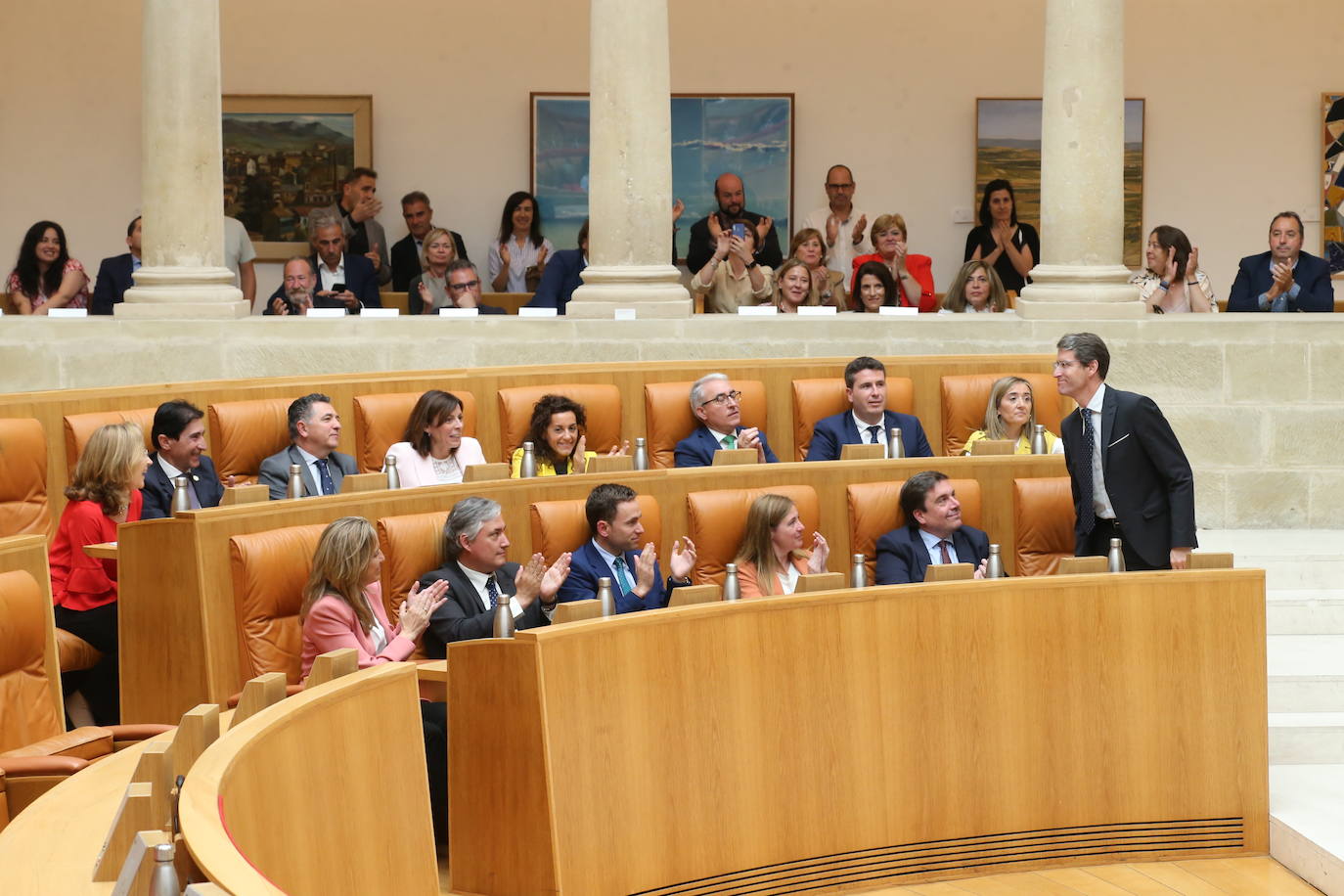 Capellán, en su asiento en el Parlamento, recibe el aplauso de sus diputados y de asistentes al pleno.