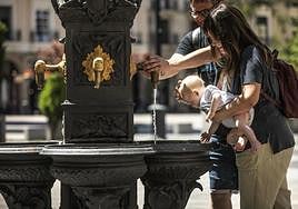 Una pareja refresca a su bebé en la fuente de la logroñesa plaza del Mercado, ayer.