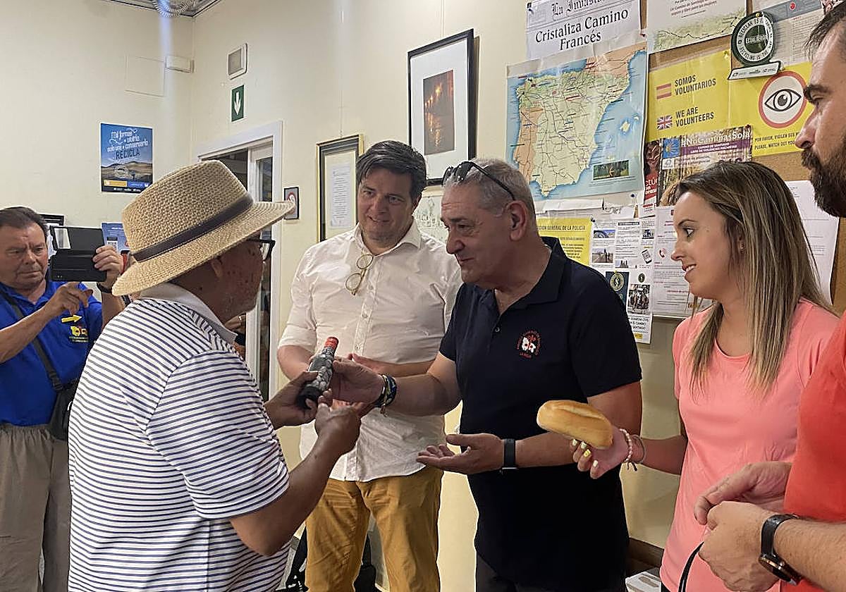Un peregrino recibiendo el pan y vino al llegar al albergue municipal de Logroño.