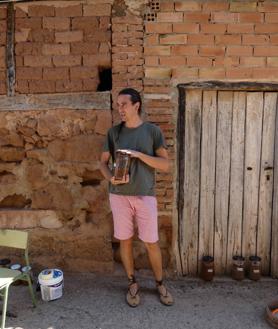 Imagen secundaria 2 - Sofía Moreno explica su intervención basada en postales; Estela Ferrer, a la izquierda, con su obra 'Lavandera', y Ángel Peris enseñando las muestras de tierra que ha recogido