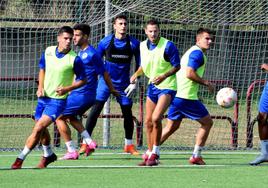 Varios jugadores de la SD Logroñés siguen con la mirada la trayectoria del balón en un entrenamiento en Pradoviejo.