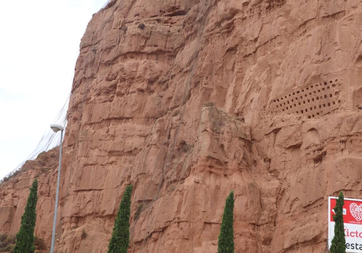 La malla protege de los desprendimientos de la ladera de la peña de arenisca sobre el casco urbano.