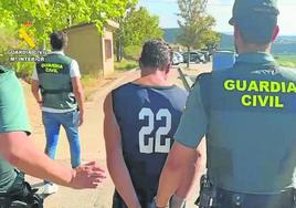 La Guardia Civil conduce esposado a uno de los dos presuntos asesinos.