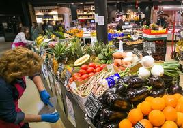 Dependientas colocan los precios de las frutas y verduras.