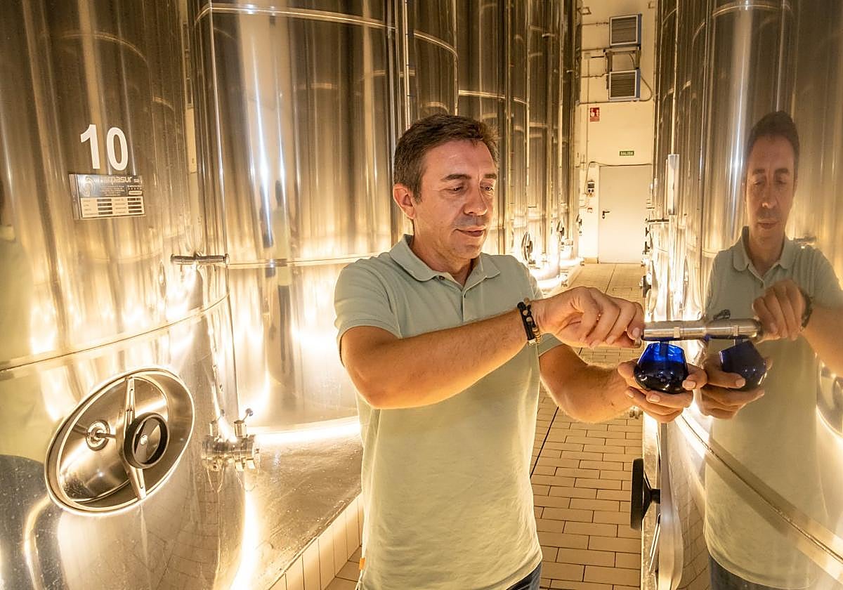 Javier Allo extrae una muestra para catar de uno de los depósitos de almacenaje.