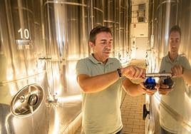 Javier Allo extrae una muestra para catar de uno de los depósitos de almacenaje.