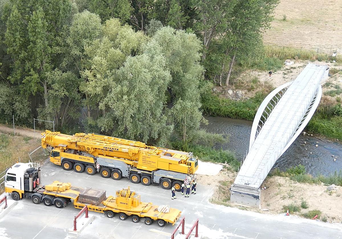Vista de las obras de la pasarela y las grúas que la colocaron.