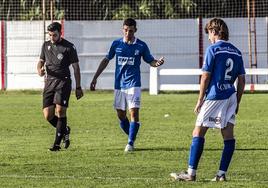 Un jugador del Arnedo conversa con el árbitro en Varea.