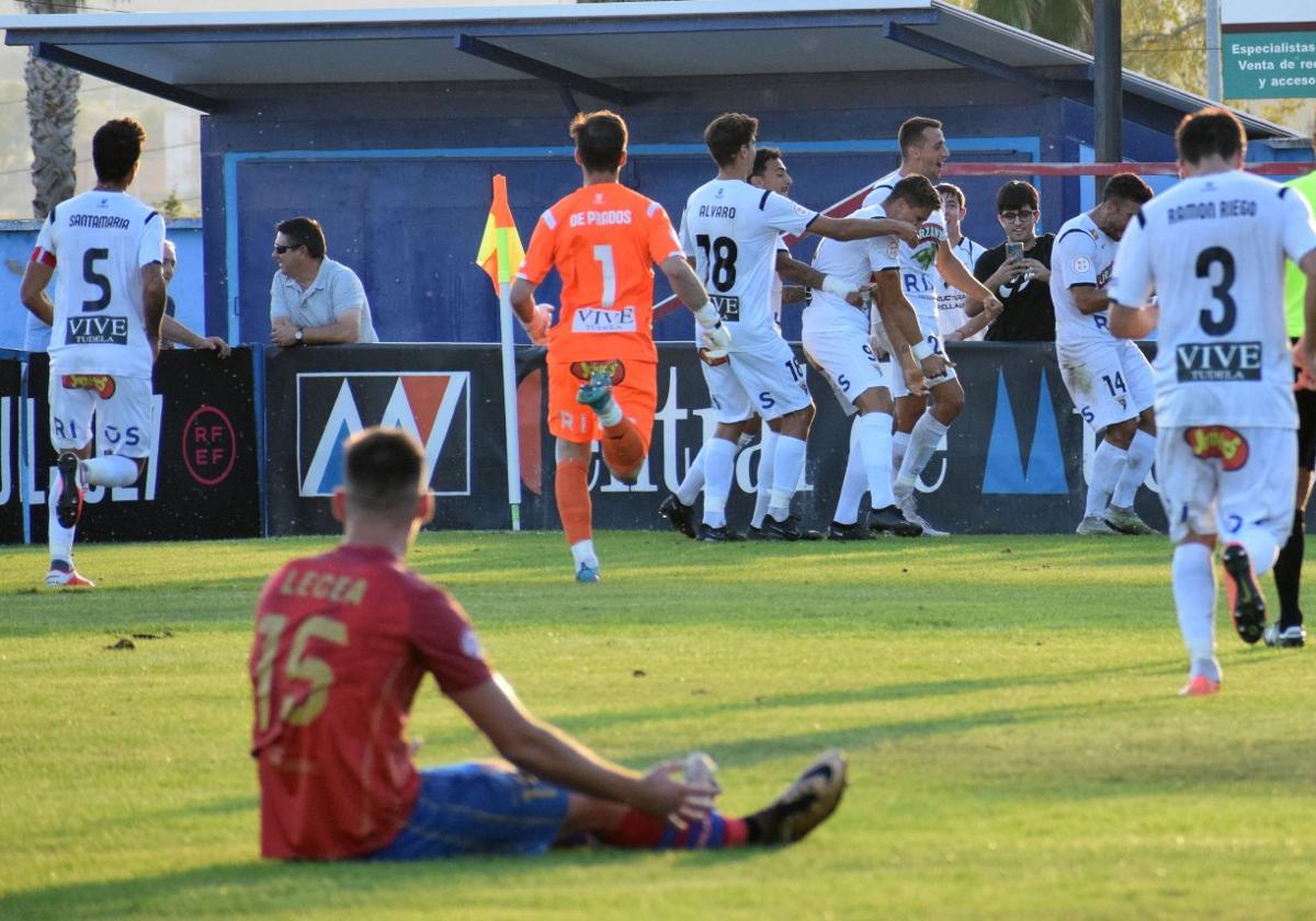 Lecea sufre mientras los jugadores del Tudelano celebran uno de los goles en La Planilla.