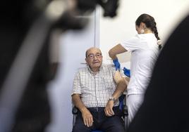 Una enfermera administra la dosis vacunal a un paciente de edad avanzada.
