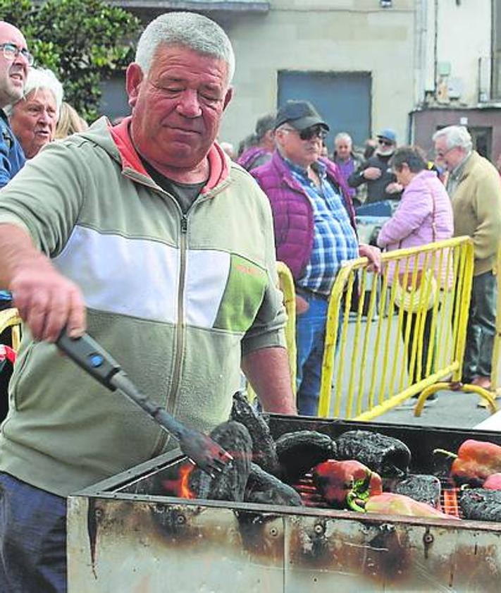 Imagen secundaria 2 - A la izquierda miembros de las Ampas de los colegios colaboraron en el evento. A la derecha el asado se realizó con leña y sin agua, de forma tradicional.