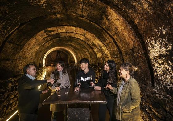 Un grupo de visitantes se dispone a catar un vino en los calados de Bodegas Tritium, en Cenicero.