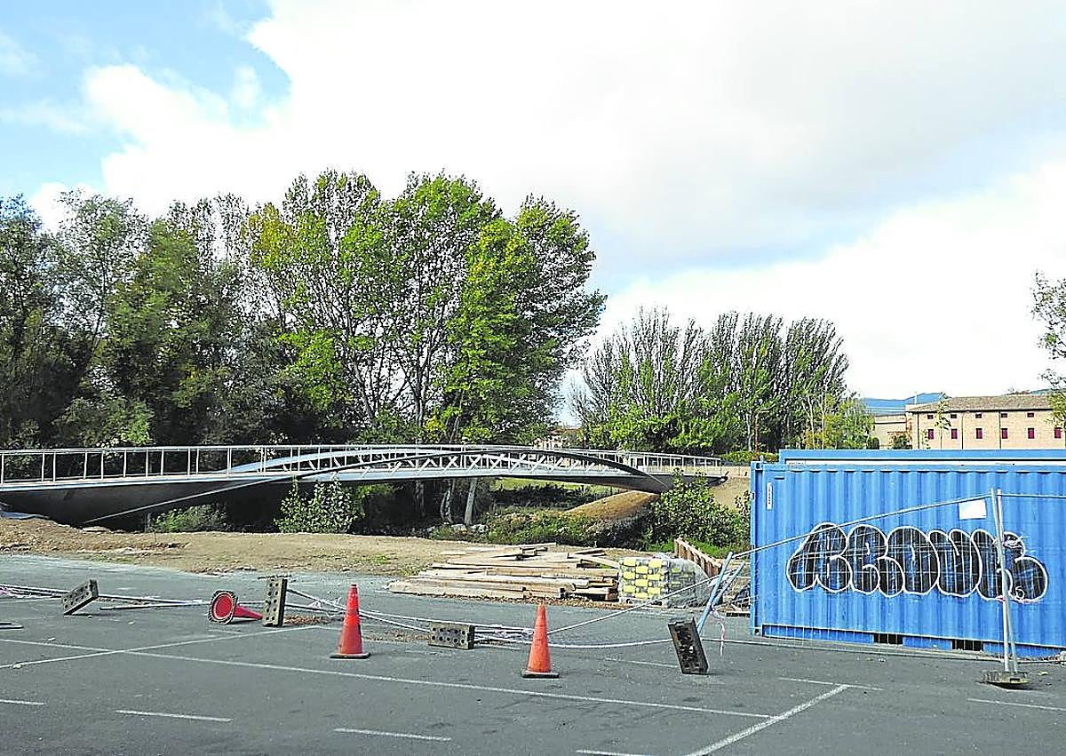 Imagen secundaria 1 - A la izquierda, una caseta y tablones amontonados junto a la pasarela.Sobre estas líneas, el final de la estructura que debería tener continuación.