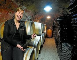 Berta Valgañón, con unas de las botellas que reposan en su histórico calado.