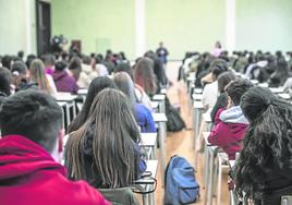 Varios estudiantes atienden a su profesor durante el primer día de inicio del curso escolar.