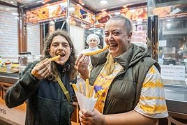 Dos clientas compran churros en 'La Exquisita', que cada día atiende en la calle Divino Maestro, frente al colegio del mismo nombre.