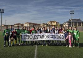 Los dos equipos, con la pancarta de apoyo a Ledo.