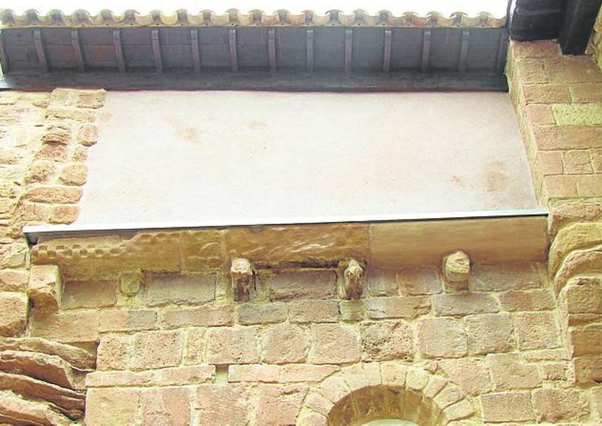 Imagen secundaria 1 - Arriba Roldán explica algunos de los aspectos de la obra durante la visita a la torre del campanario. Abajo a la izquierda cornisa románica del monasterio tras su restauración. Abajo a la derecha grieta en el interior de una de las bóvedas antes de la intervención. 