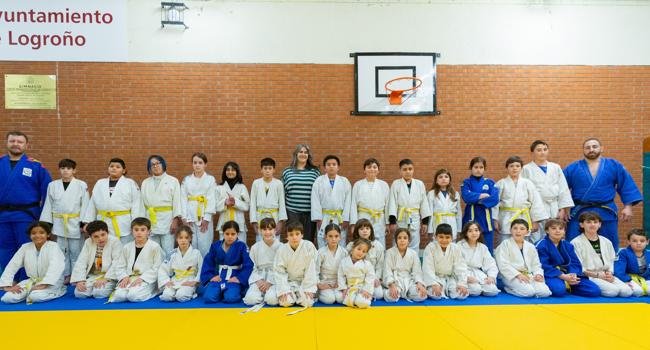 Los entrenadores de judo y la directora del CEIP Navarrete El Mudo posan con la treintena de alumnos que participan en esta actividad extraescolar del centro.